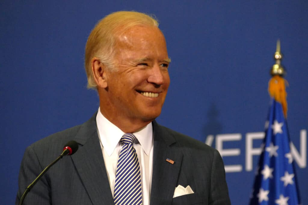 Joe Biden expresses his views through smiles at a podium.