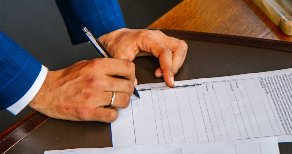 man signing a contract