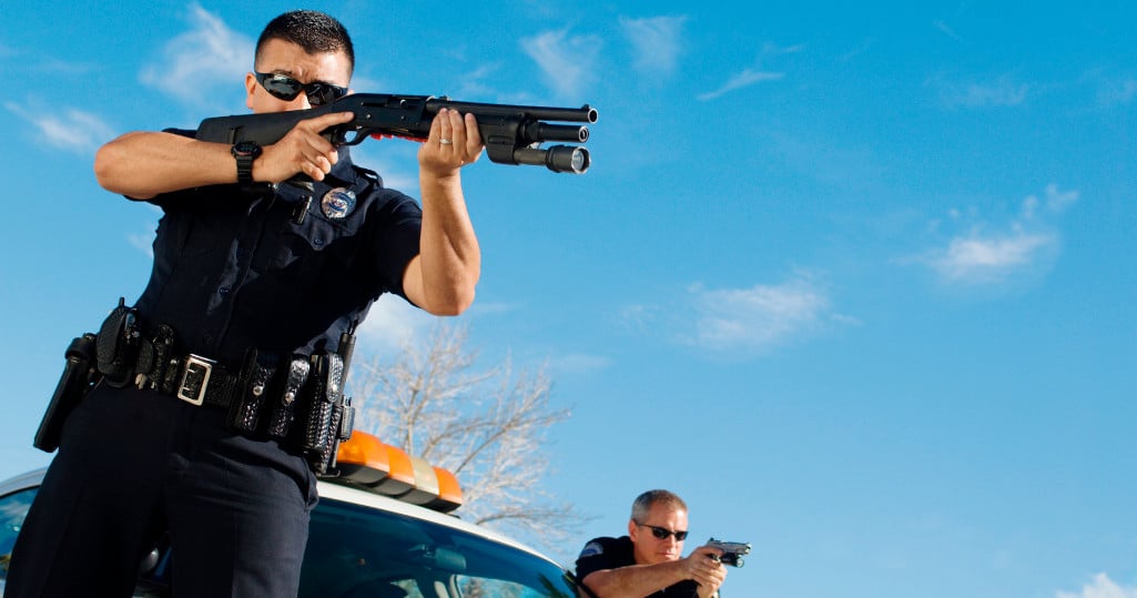 police officer aiming shotgun