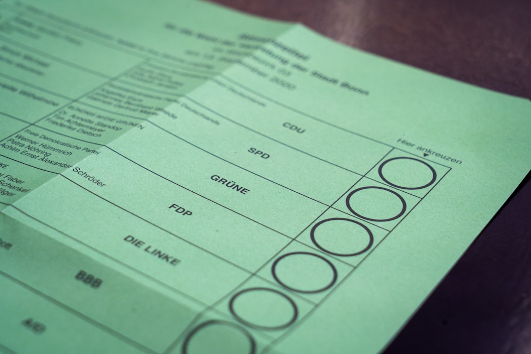 A green paper ballot features columns listing political parties: CDU, SPD, GRÜNE, FDP, DIE LINKE, with circular checkboxes for voters to elect their choice in the election.